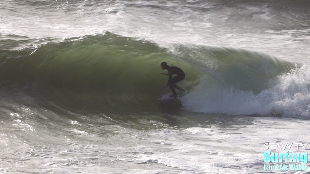 surfing a california sandbar wave that has hollow barrels